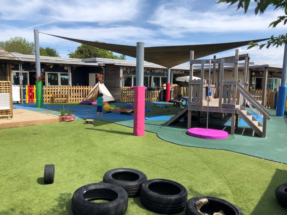 "outdoor space at Acorn nursery with climbing apparatus and toys"