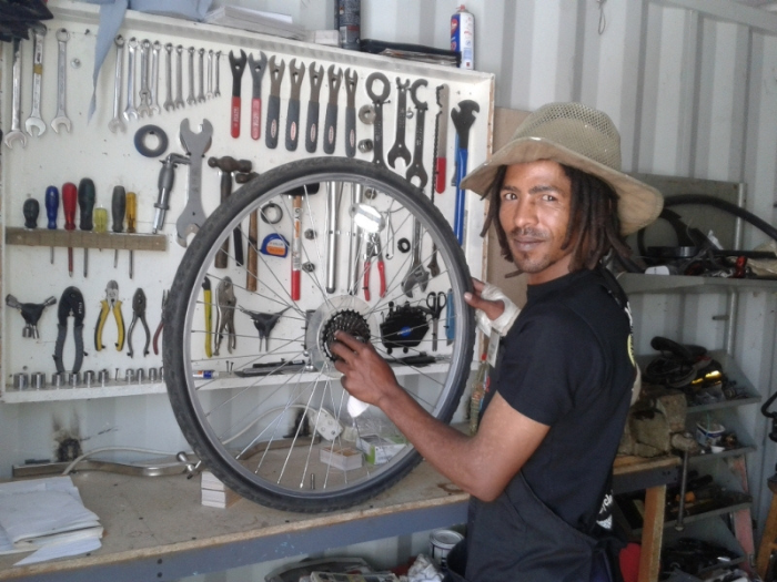 A picture of a man holding a bicycle wheel
