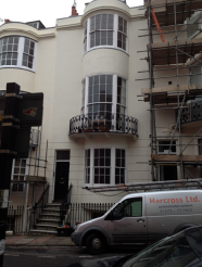  A white townhouse on three floors plus basement. It has a curved bay window to the ground, first and second floors with a decorative cast iron balcony to the first floor.