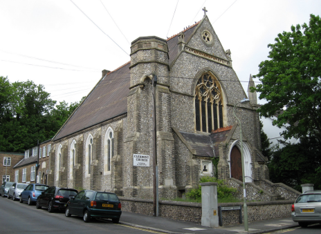 A grey stone church with gothic style columns and windows