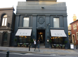 A lagre black building over two floors with a fine dining resturant frontage on the ground floor.
