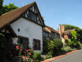 Varied tiled roofs and tall decorative chimney stacks. Rendered, mock timber framing, flint walls and brick dressings. Carved timber bargeboards to gables. Leaded windows throughout.