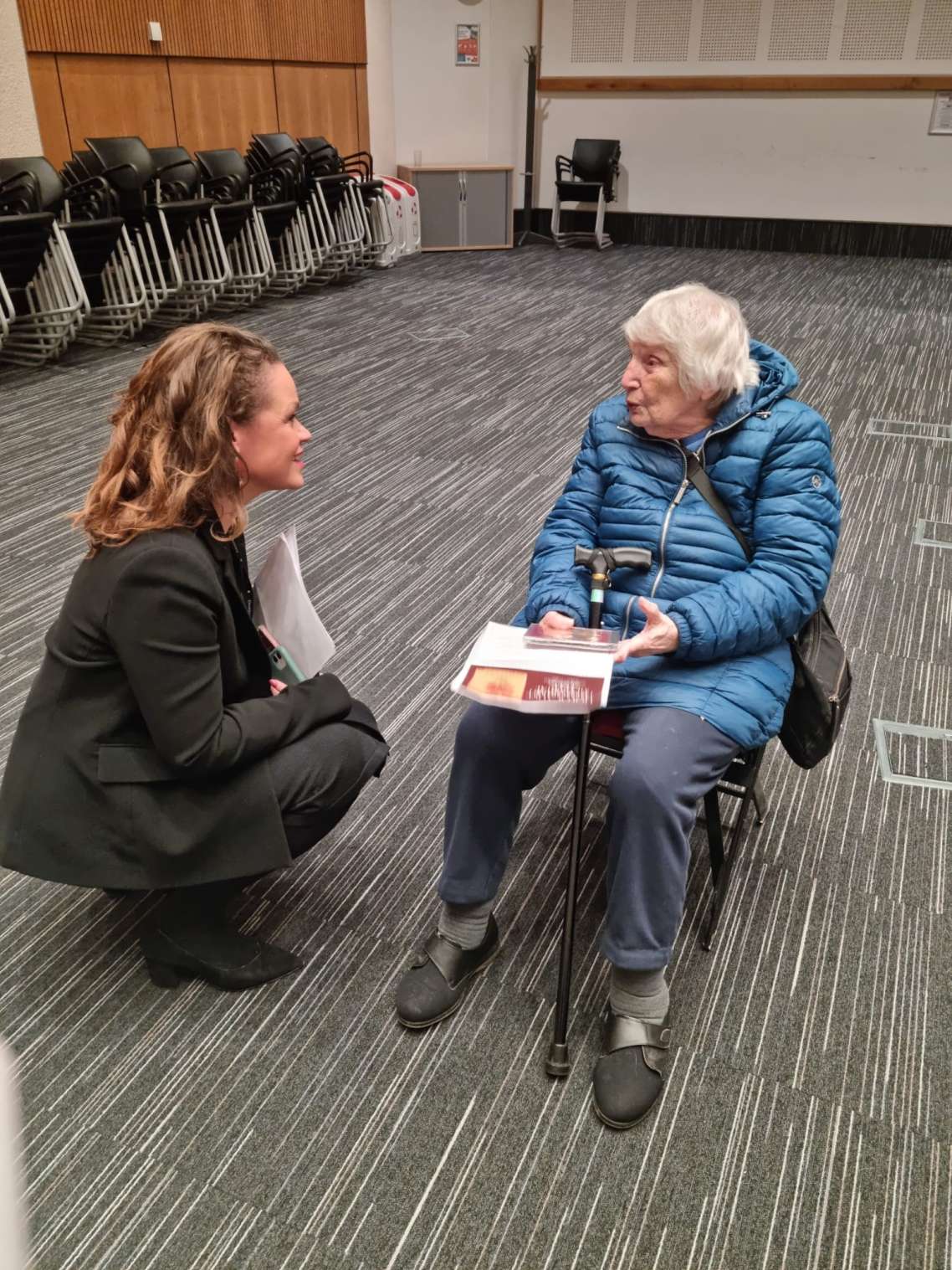 An image showing Council Leader Bella Sankey who is kneeling while talking to Holocaust survivor Ceska Abrahams who is sat down