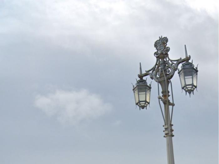 a picture of a lamp post with two decorative lanterns having from it