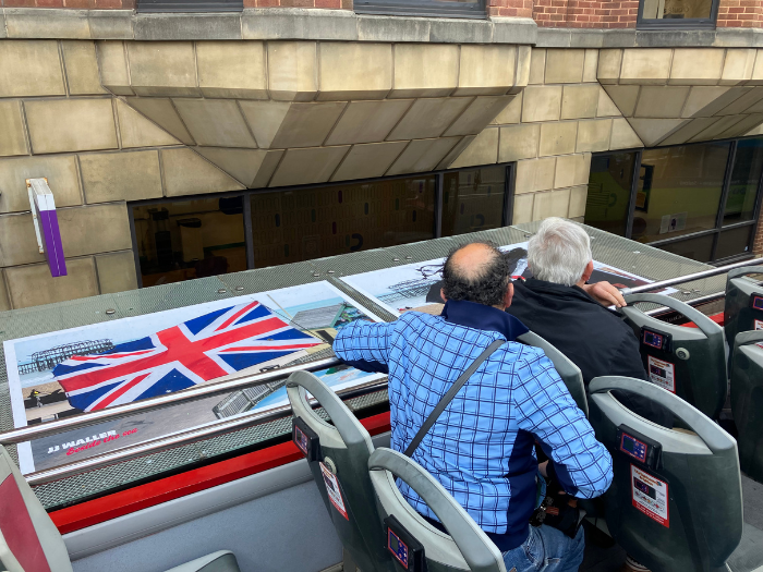 Two people looking at artwork on top of a bus shelter