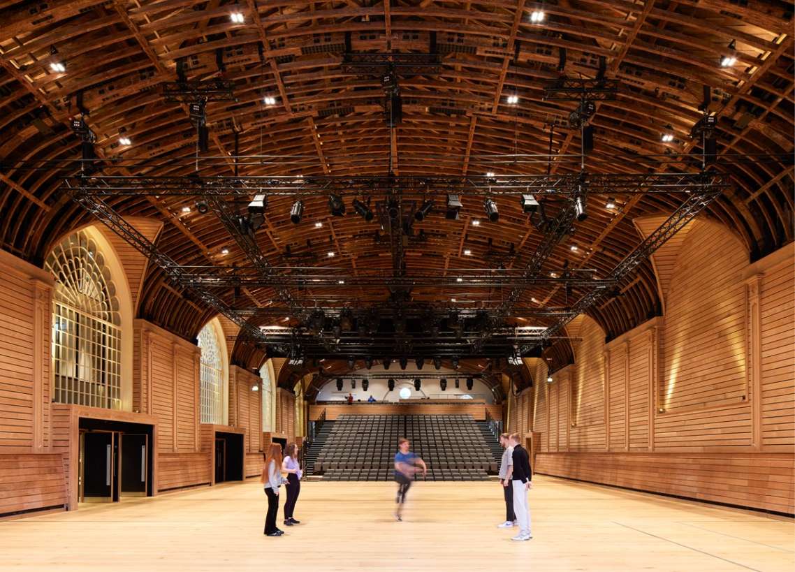 The renovated hall at the Corn Exchange, with a group of five people performing dance.