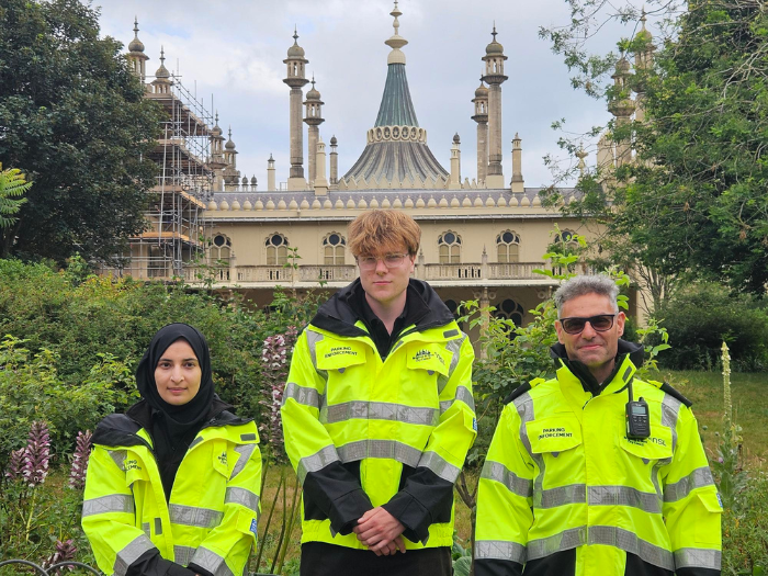 three people standing in front of Brighton pavilion in Hi-viz jackets