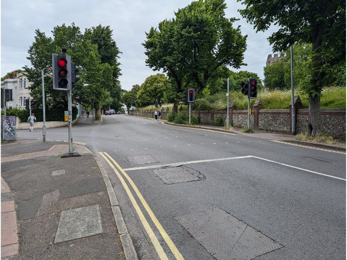 A picture of a road junction with traffic lights and trees