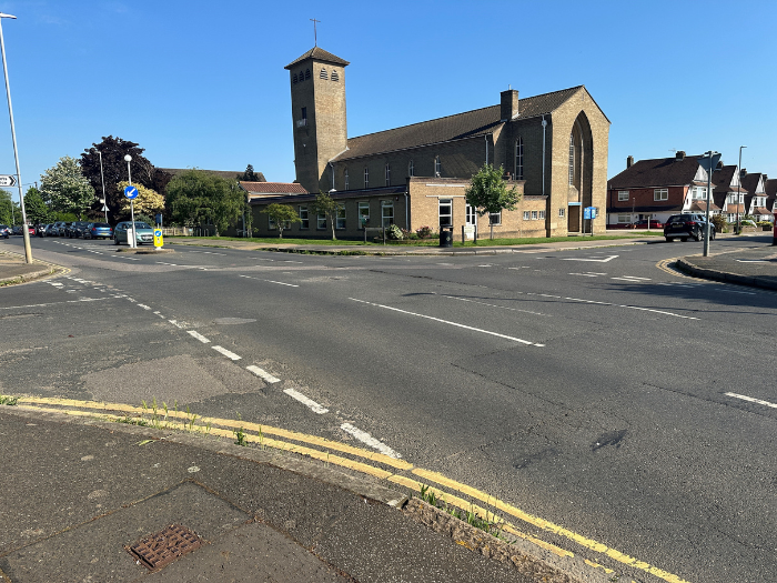 A photo of a road junction with a large building in the background