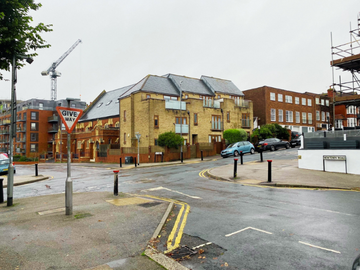 A picture of a road junction with houses in the background