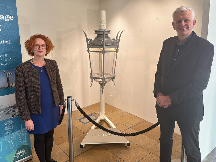 Two people standing next to a large lantern
