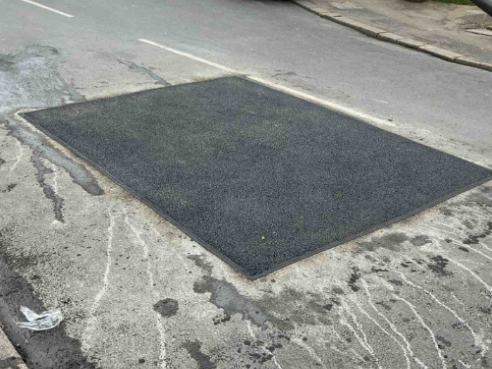 A road with a pothole patched and repaired