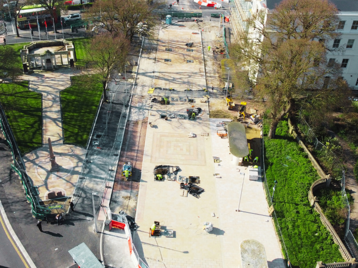 A newly laid pavement between a war memorial and buildings