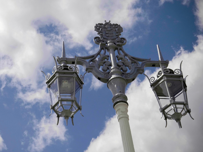 a streetlight in front of a sky and clouds