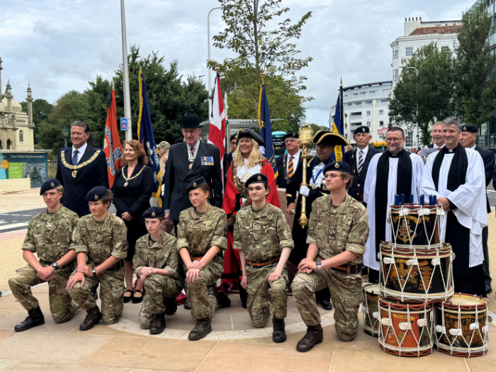 a group of people posing for a photograph, some wearing military attire