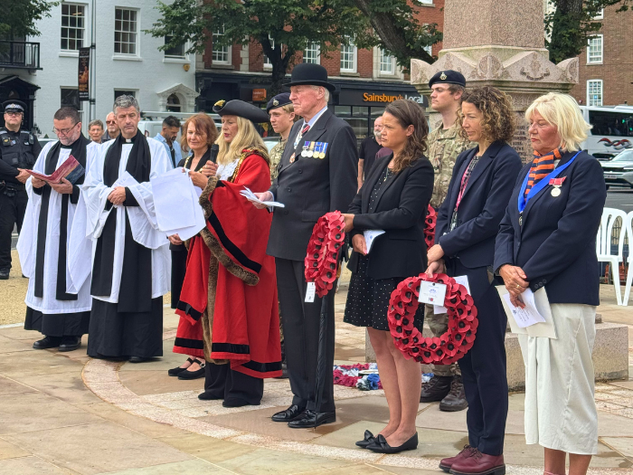 people standing at a war memorial. 