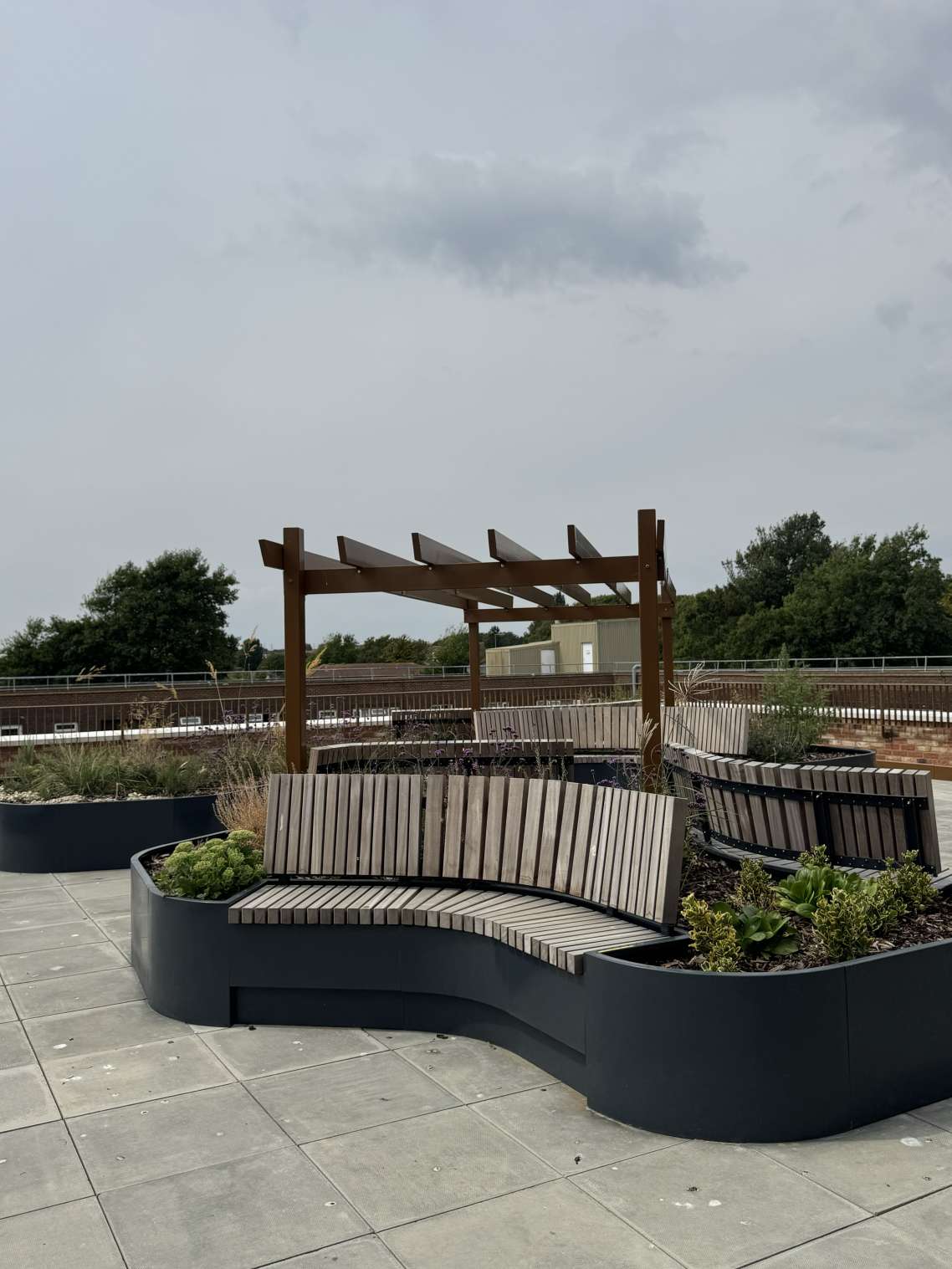 A photo of the rooftop garden with greenery and benches on top of the Brickfields supported living scheme.