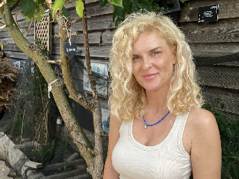 Gosia Malgorzata in front of wooden background next to tree