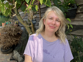 Leonie in front of wooden wall and tree