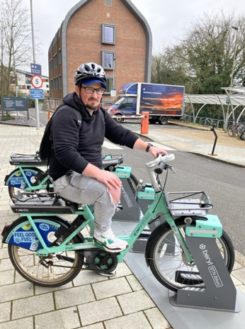 Man in black hoodie and grey jeans sitting on electric Beryl Btn bike.