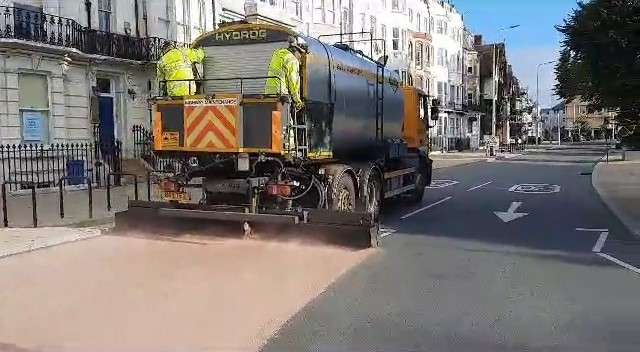 Photograph of a truck resurfacing the road with reclamite.
