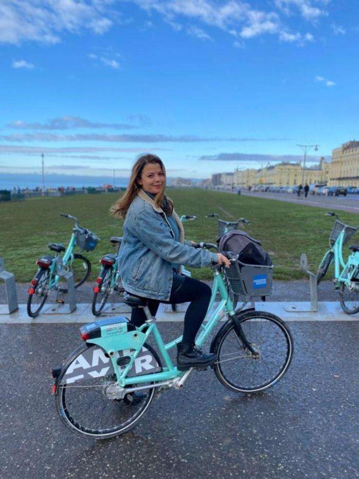 Person on a BTN Bikeshare bike on Hove seafront.