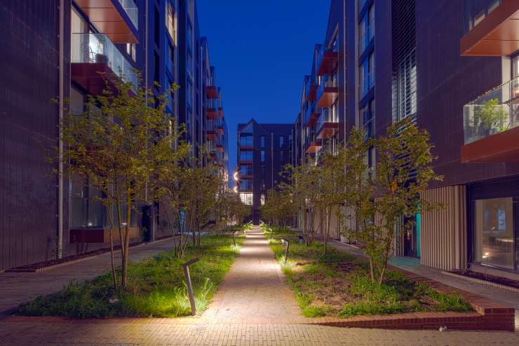 A residential block of Circus Street at night. The tree-lined green space is illuminated.