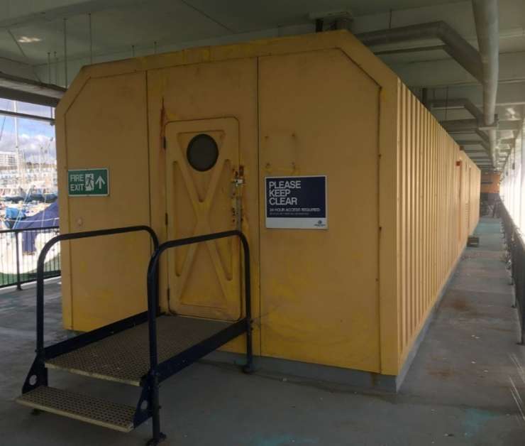 A photograph of one of the yellow GRP structures showing the main entrance.