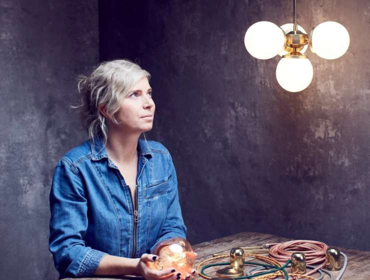 A photograph of a woman from Spark and Bell looking at lighting