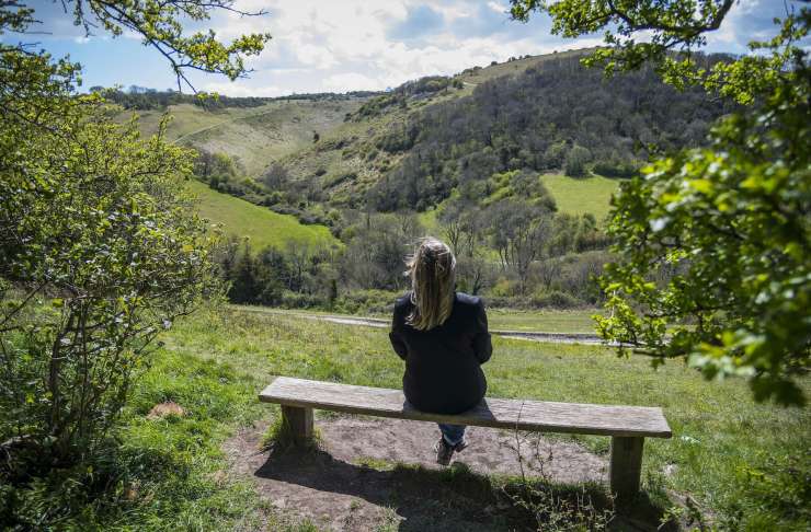 Person sitting on bench overlooking Devils Dyke.