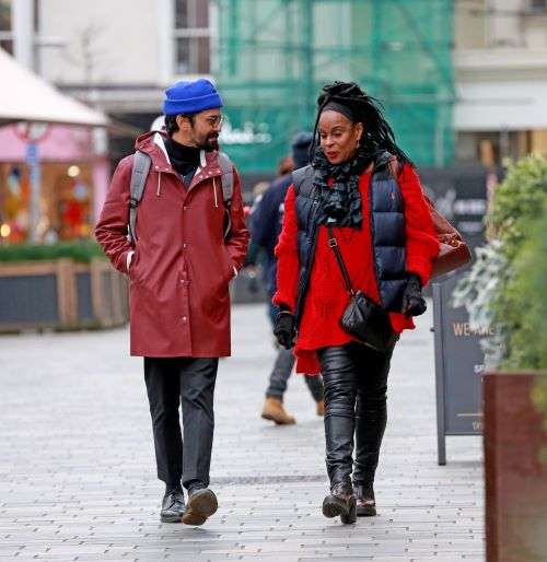 A man and a lady walking through the centre of Brighton. 