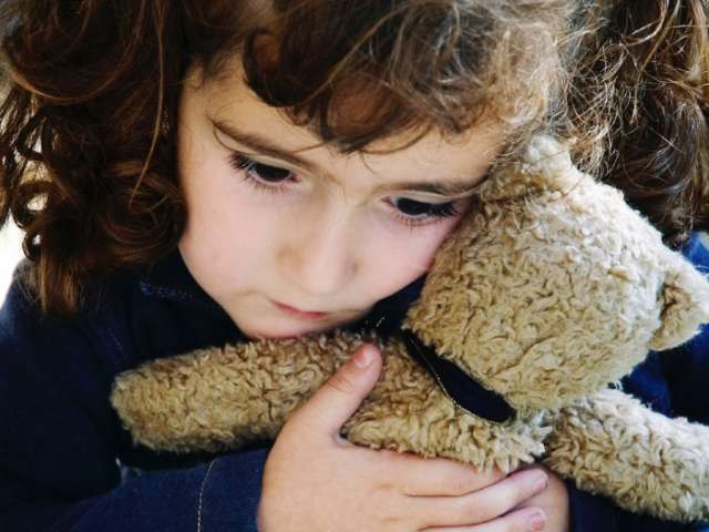 A child hugs a teddy bear