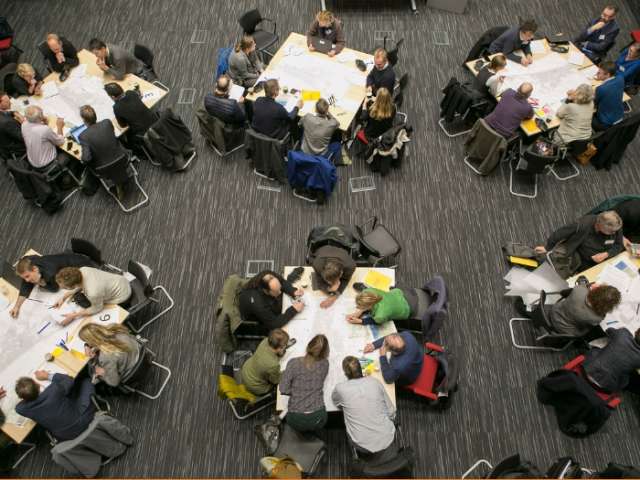 Designers collaborating in small groups at the annual design conference known as the 'charrette'