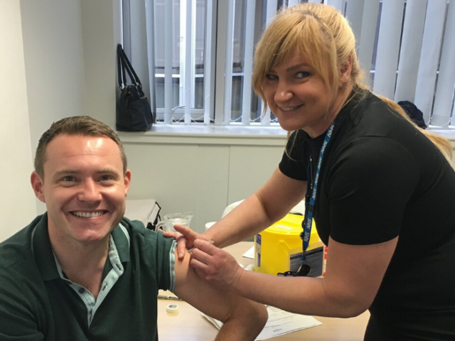 Man getting a flu vaccination from a nurse