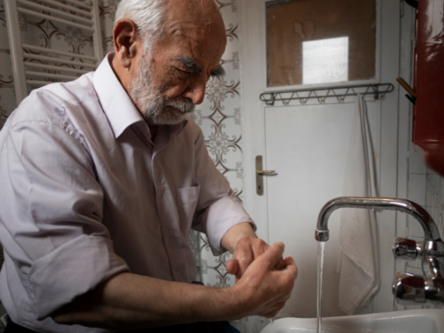 Older man washing hands