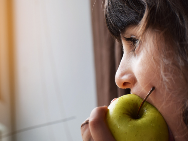 Photo of a child eating an apple