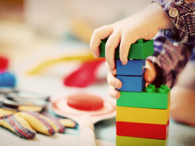 Photo of a child's hands playing with building blocks