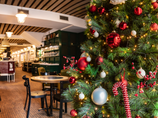 Inside of an empty pub/restaurant with a Christmas tree decorated with red and silver baubles