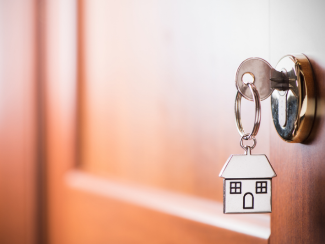 Internal door with key in the door and picture of a house on the key fob