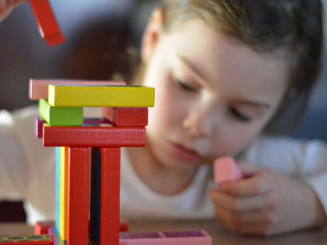 child playing with wooden bricks