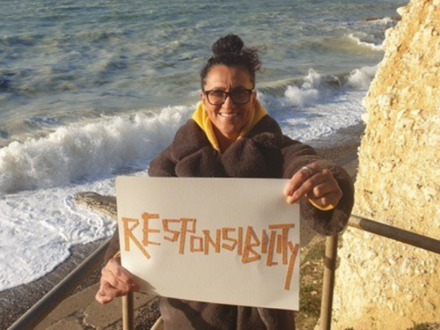 Photo of Brighton & Hove life coach Sam Adams holding a notice reading 'Responsibility'.