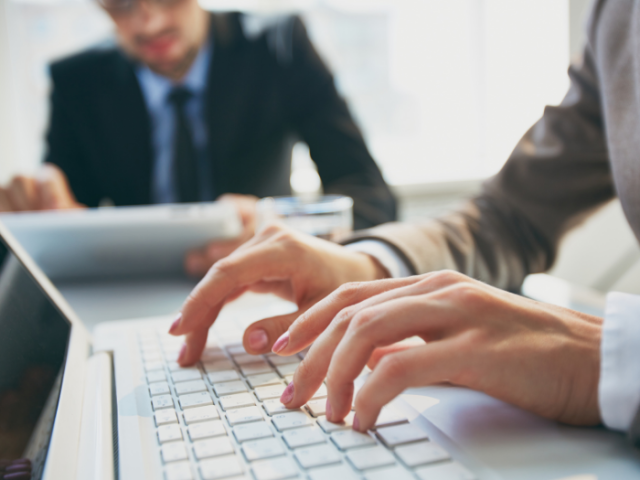 Two people applying for grants on laptops