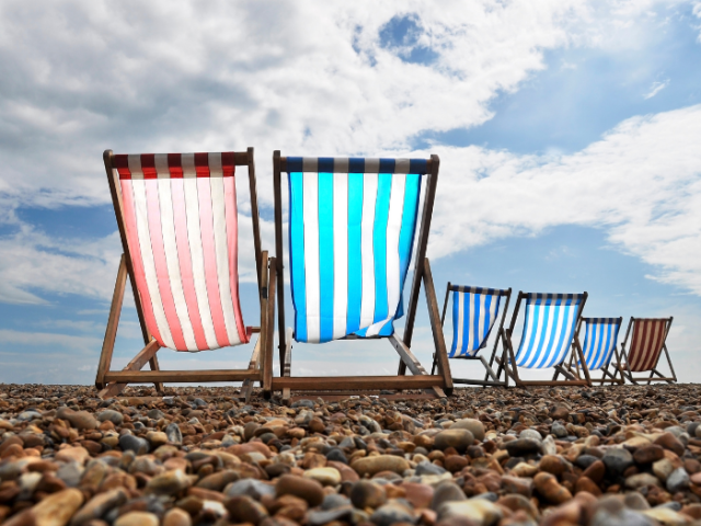 Deckchairs on Brighton beach red and white and blue and white, set out in pairs