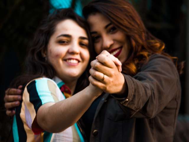 two women holding hands and smiling