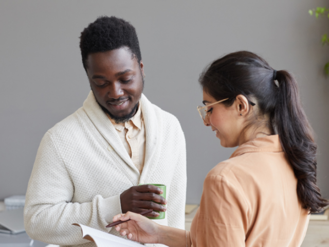 Image of a man and woman talking at work 