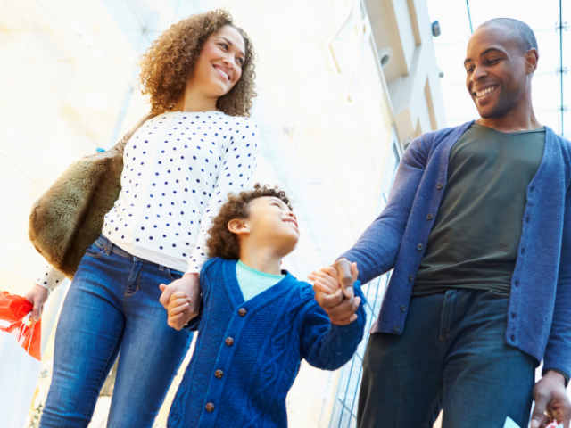 Mixed-race woman and Black man hand in hand with a young boy