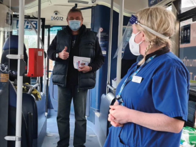 Interior of mobile vaccination bus with man and healthcare worker