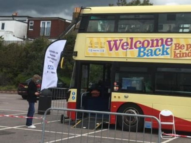 Photo of a bus in a car park being used for vaccinations