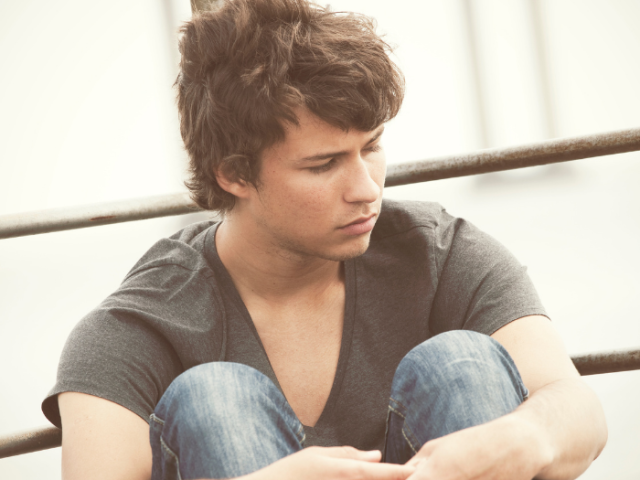 unhappy teenage boy wearing T-shirt and jeans