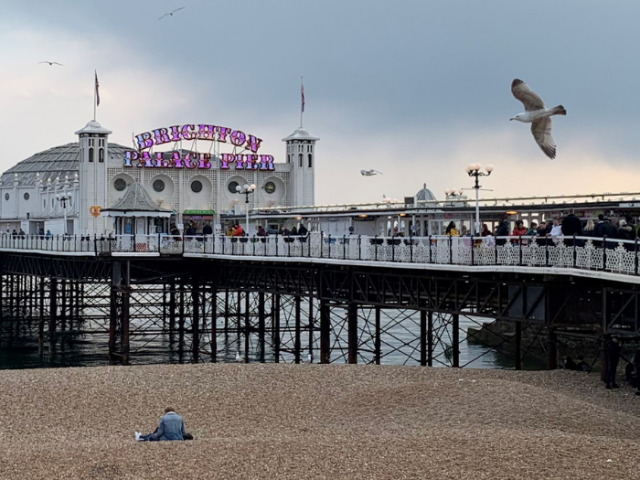 Photo of Brighton Palace Pier with the sign in purple.